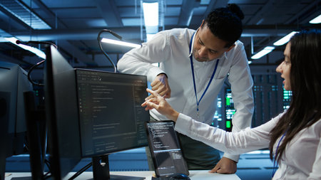 Team of admins in data center ensuring system can handle networking tasks. Teamworking colleagues in...
