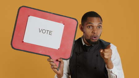 Catering employee showing a message on red speech bubble, presenting the cardboard icon. Waiter in...