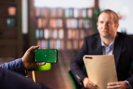 Multiethnic secret agents discussing next to isolated copy space on display, meeting in the bureau library to discuss important mission details. Secure information and professional camaraderie.の写真素材