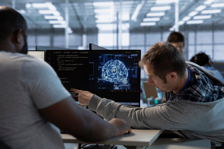 Team of admins does data center workplace automation using AI and machine learning tools. Teamworking colleagues integrating artificial intelligence driven automation in server hub facility operationsの写真素材