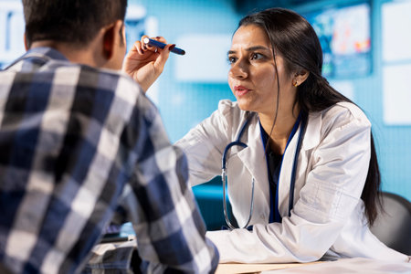 Ophthalmologist reviews eyesight with optical light tool at consultation, diagnostic tools and modern technology. Patient receiving treatment for optometry issues in healthcare office.の写真素材
