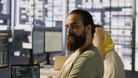Portrait of smiling machine learning infrastructure engineer developing algorithms to learn from data. Cheerful man in office training and deploying large scale deep learning models, camera Aの写真素材