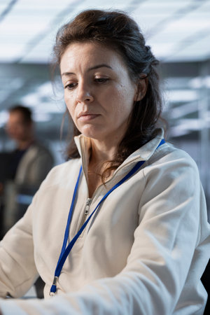 Data center system administrator developing disaster recovery plans ensuring minimal downtime. Server farm specialist uses data analytics to monitor performance and predict future infrastructure needsの写真素材