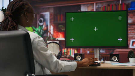 Teleworker using green screen PC in home office to write emails. Remote worker typing on mockup computer keyboard, composing documents in order to deliver finalized project paperwork, camera Bの写真素材