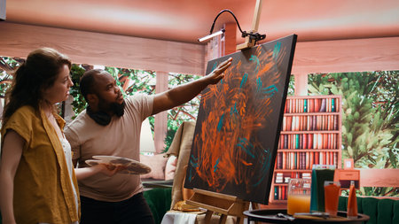 Talented artist and her apprentice engage in finger painting hobby in art and craft workshop, using modern painting technique to create abstract masterpiece. Vibrant colors on canvas. Camera B.の写真素材
