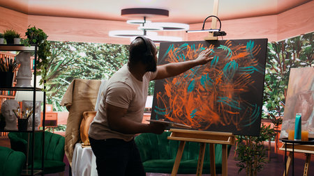 Painter applies watercolor paints to a canvas with his fingers, creating stunning piece of fine art. Use vibrant colors and finger painting techniques to reflect creativity and inspiration. Camera B.の写真素材