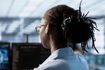 Woman sitting at computer desk, finishing programming tasks in AI data center used for machine learning training. Close up shot of engineer upgrading artificial intelligence techの写真素材