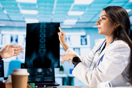 Indian healthcare professional sharing medical expertise with a patient in office, examining x ray...