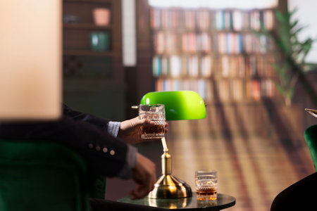 Modern multiethnic entrepreneurs talk business strategy over scotch in a luxurious elite social club, capturing the essence of upper class professionalism. Old money society members.の写真素材