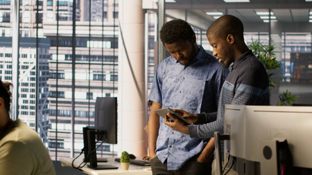 Technician and colleague using device for managing cloud computing platforms training machine...