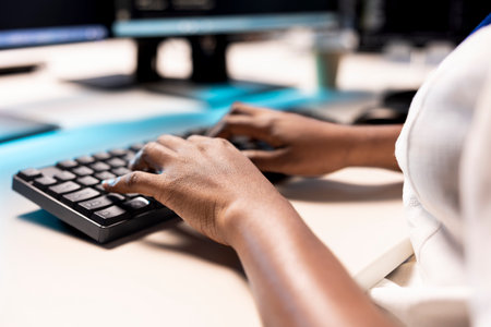 Data center employees typing on PC keyboard, creating technical documentation for software applications. Close up of programmer in server room using computer, maintaining databasesの写真素材