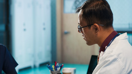 General practitioner recommending vitamins and painkillers on healthcare insurance, writing a prescription document with instructions and the right dosage of medication. Camera A.の写真素材