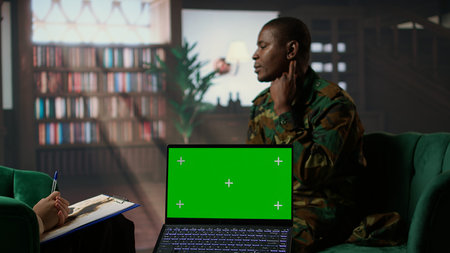 Army veteran at counseling shares war related anxiety next to isolated screen, discuss about psychological issues and infantry shell shock syndrome. Trooper listens to professional advice. Camera A.の写真素材