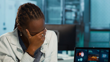 African american female doctor discussing a cancer diagnosis with patient, reviewing biopsy results, MRI scans and targeted treatment options like chemotherapy and immunotherapy.の写真素材