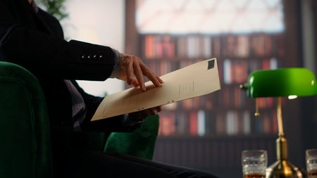Two espionage agents reviewing confidential documents in a vintage library, emphasizing secret service teamwork and strategic planning for a mission. Reading government reports. Camera B.の写真素材
