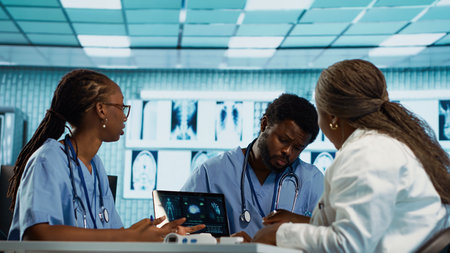 Group of healthcare specialists in scrubs analyzing results with doctor, emphasizing teamwork,...