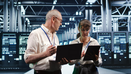 Tech support consultants monitoring energy efficient data center infrastructure. Server parts using...