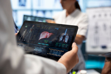 Professional doctor analyzing lungs and liver radiography test result for diagnostic, working on disease prevention in cabinet. Specialist at private clinic examine ct scan and x ray. Close up.の写真素材