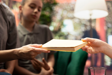 Therapist recommends self care book to help mother with valuable advice on supporting teenage daughter dealing with depression, focusing on emotional awareness and family wellness. Close up.の写真素材