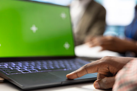 Organizational staff looking at device with green screen during a meeting, ensuring progress for an...