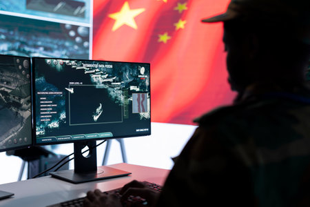 Military analyst from China reviews surveillance data in an army monitoring room headquarters....