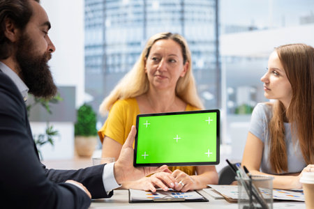 Broker holding green screen tablet, meeting with clients to provide stock exchange analysis....