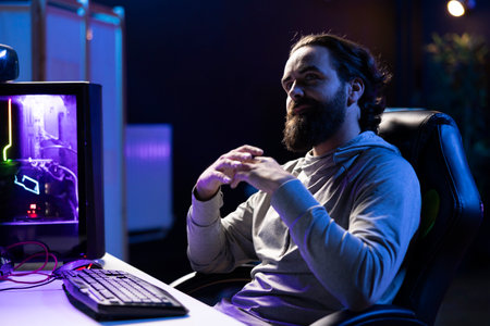 Content creator playing videogames live while chatting with online audience from neon lit apartment....