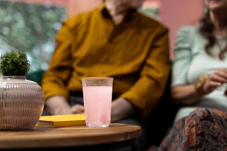 Old man and woman throwing their effervescent vitamin pills in a glass of water, drinking their daily dose of wellness supplements. Elderly people following treatment, personal care.の写真素材