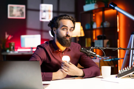 Content creator holding smart light bulb under face to create creepy mood in studio while telling...
