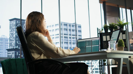 Successful female entrepreneur oversees a strategic review of the company activity, analyzing market...