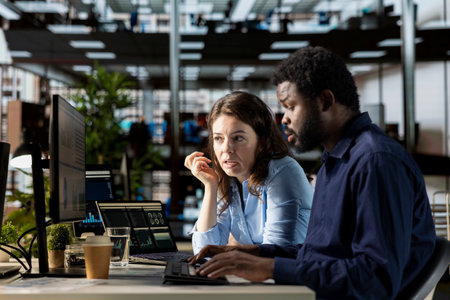 Diverse staff in the office engaged in infographics analysis for problem solving tasks, financial planning to support business growth and accomplish strategic objectives. Multinational company.の写真素材