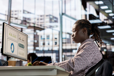 Black business manager engaged in budget analysis and strategy development at workstation,...