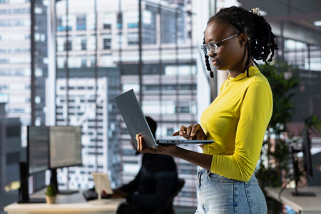 Cybersecurity expert using laptop to look for company security vulnerabilities, comparing with...