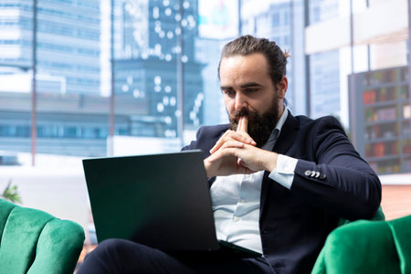 Career driven professional boss sitting in a modern workspace, focusing on strategic investment planning and ensuring sales growth. Strengthening his corporate leadership position.の写真素材