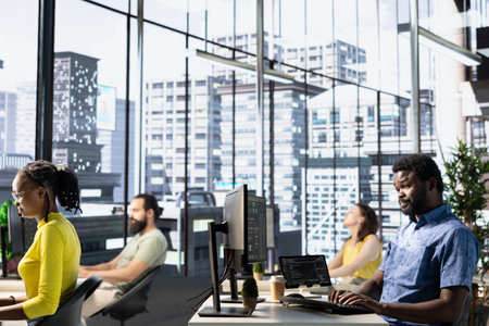 IT staff members utilizing cloud computing resources and platforms to train and deploy large scale machine learning models. Team of programmers monitoring and maintaining company systemsの写真素材