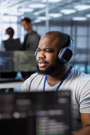 Engineer in data center listening to music, optimizing IT infrastructure using network management...