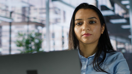 Smiling indian general manager focused on business operations, reviewing a project brief in order to...