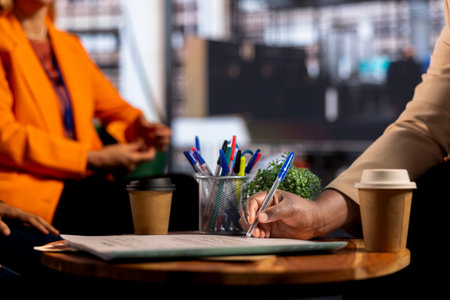 Female executives review legal paperwork and finalizing an important deal, signing banking documents and highlighting progression. Productivity in a male dominated business industry. Close up.の写真素材