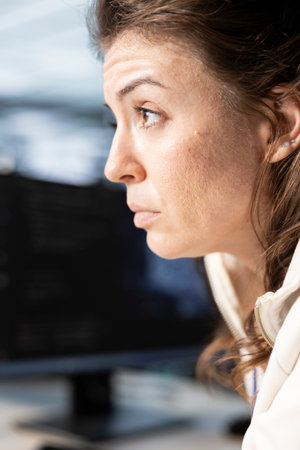 Technician in data center workplace coordinating deployment of server architecture, improving data...