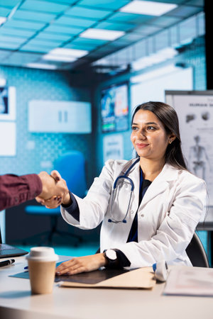 Female specialist welcoming her indian male patient at check up visit, attending a consultation...
