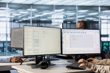 Lines of code running on computer screens in data center, used by employees to troubleshoot rackmounts in server rows. IT scripts ran by workers on PC monitors, upgrading hardwareの写真素材