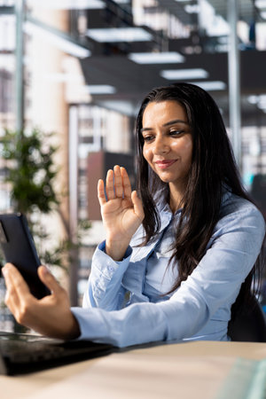 Indian businesswoman participates in a virtual collaboration with investors, discussing corporate goals and resource planning. Manager enhances remote work via video call, successful business.の写真素材
