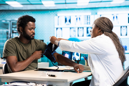 General practitioner measuring blood pressure with a blood pressure monitor, checking the pulse and heartbeat with a modern tool. Control measurement and readings in a cabinet.の写真素材