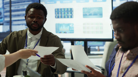 Team of business associates reviewing statistics and infographics on a tablet, working to gather insight for enterprise development. Employees discussing legal changes at a meeting. Camera A.の写真素材