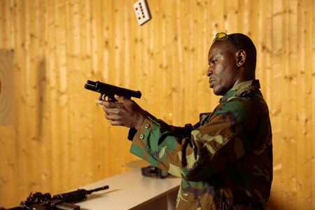 Man in uniform doing intensive shooting course designed to elevate individual skills beyond basic marksmanship. Military unit using pistol to engage targets at various rangesの写真素材