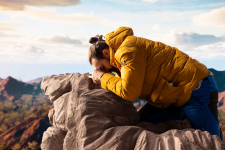 Hiker getting exhausted at the top, slipping on rocks causing an accident and risking his life. Young unprepared tired climber losing balance.の写真素材