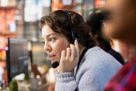 Customer service employee talking in headset mic, tracking support ticket in dedicated company...