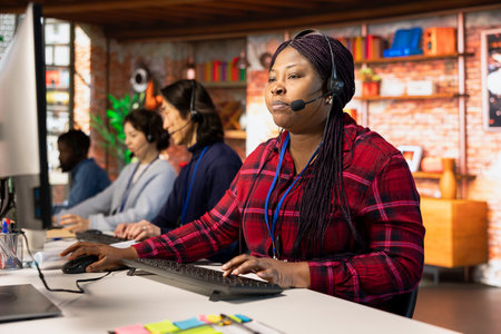 Team of multiethnic call center agents in workplace helping customers regain access to accounts. Multiracial workers in diverse customer center assisting clients needing help resetting passwordの写真素材