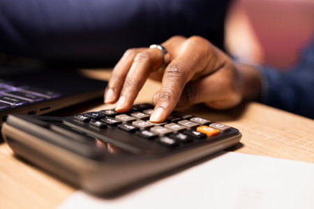 People using calculator to manage business taxes and accounting, tracking expenses for effective...