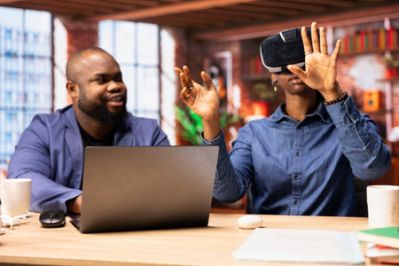Black couple balances remote work and technology at home office, interacting with VR glasses....